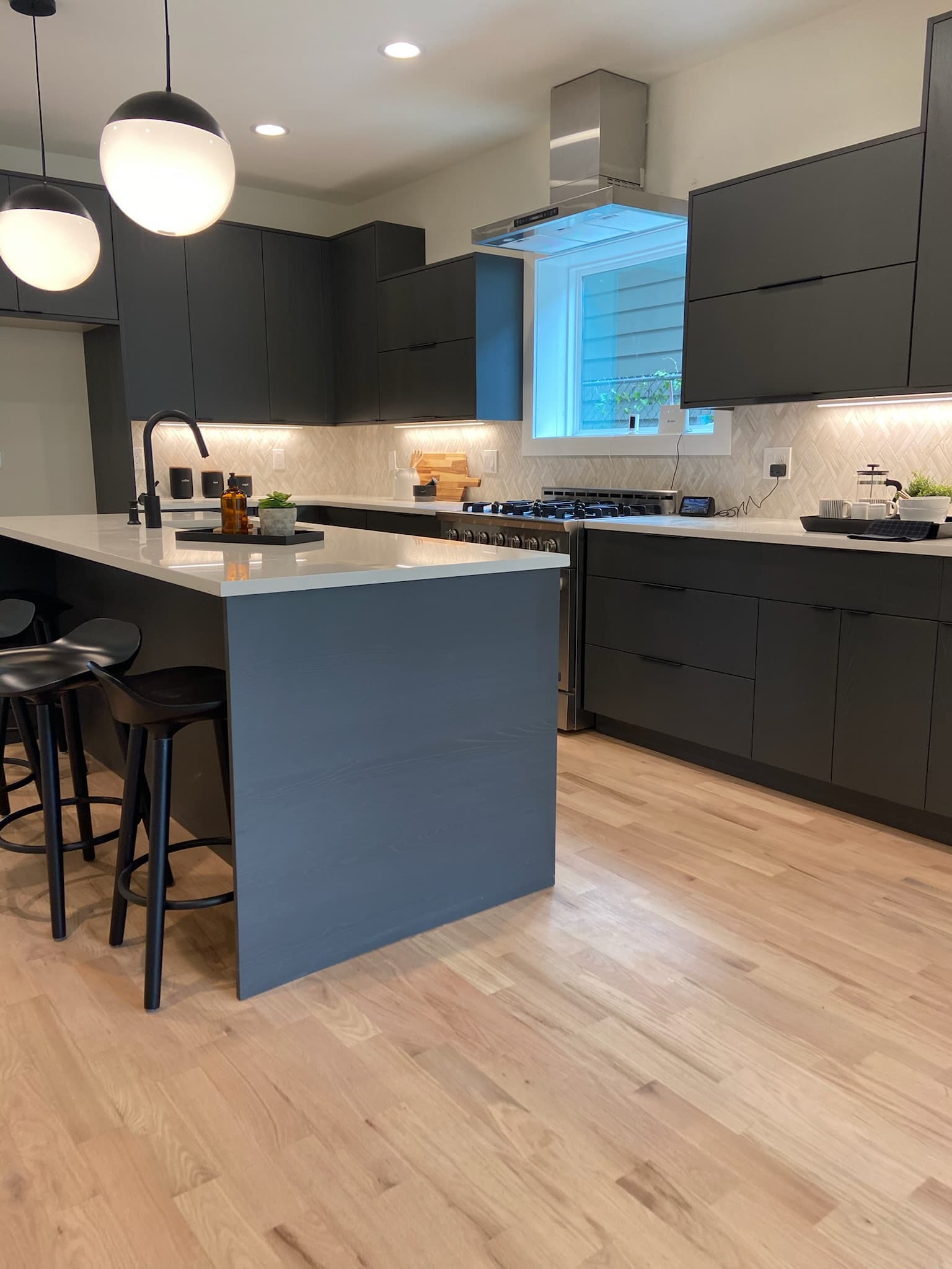 Modern dark kitchen with herringbone backsplash